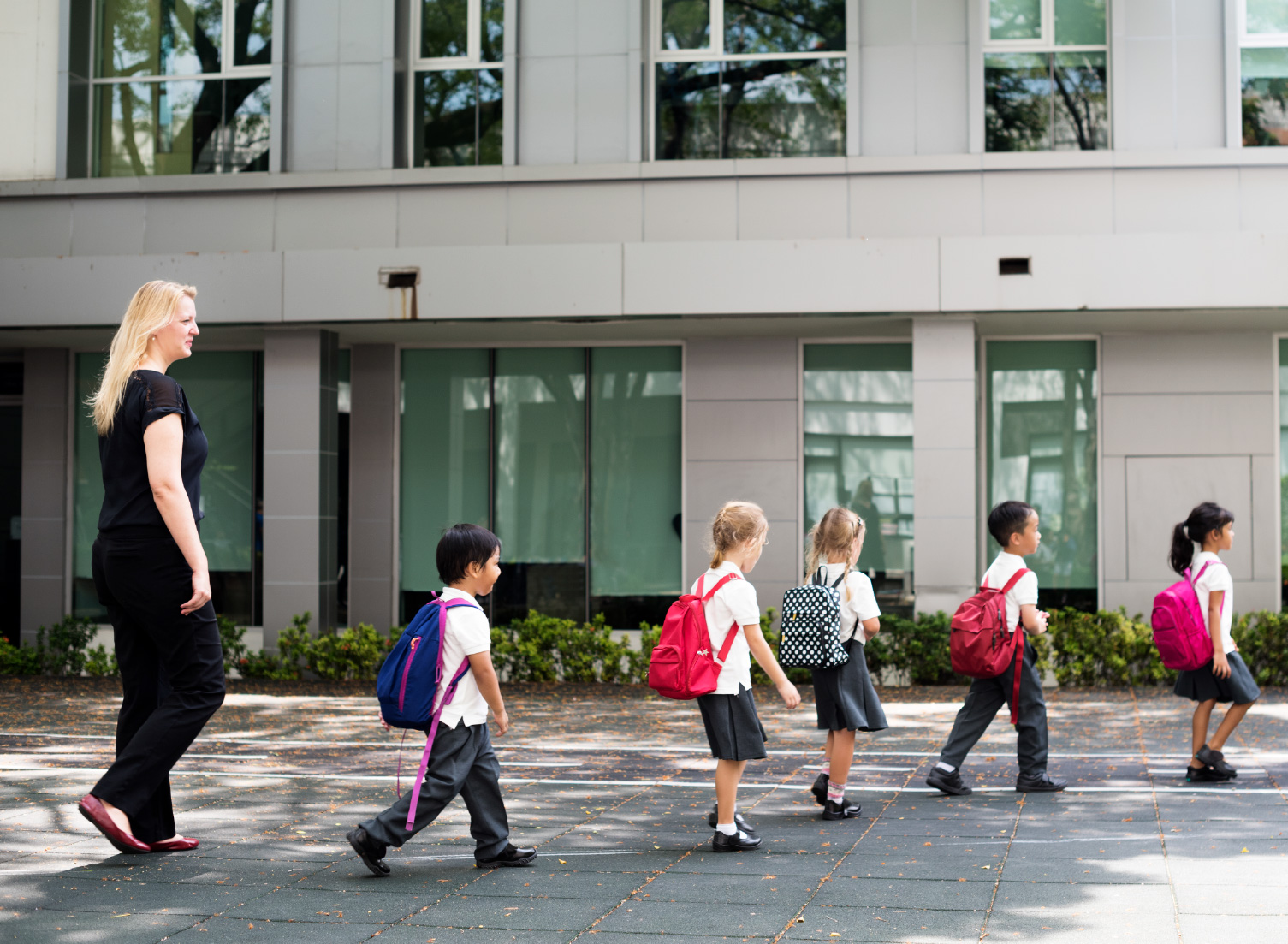 children being guided by a teacher during a fire roll call